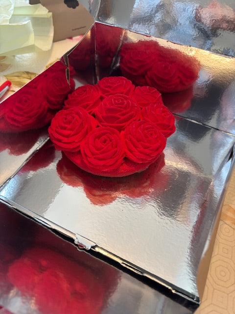 Close-up of a raspberry-shaped tart from Cédric Grolet Opéra on a café table, surrounded by pastry tools and floral accents—symbolizing artistic, fruit-first French desserts.