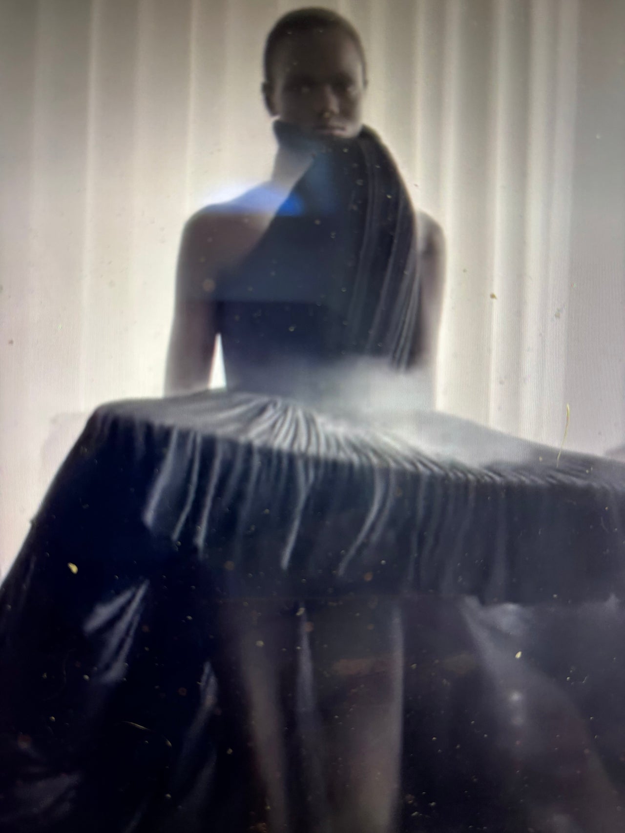 Model wearing a dramatic couture outfit emitting smoke while walking the runway during Jean Paul Gaultier’s Spring/Summer 2026 fashion show, creating a theatrical and surreal visual effect.