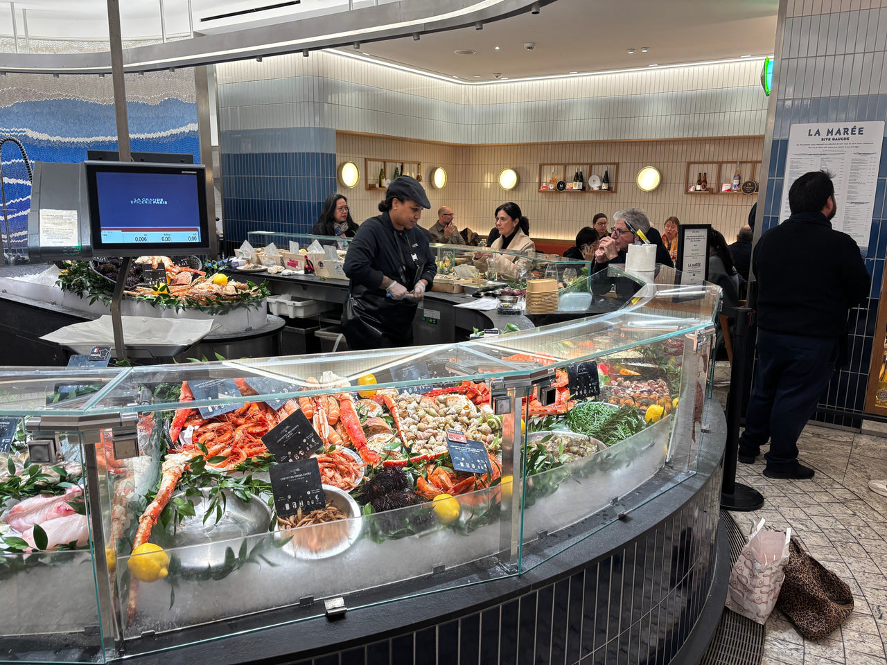 Fresh oysters and seafood displayed inside a luxury Paris food market, representing La Marée’s high-end seafood experience.