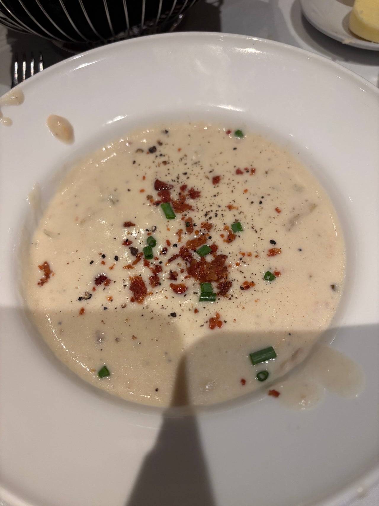 New England clam chowder at Abe & Louie’s in Boston served in a cup, featuring fresh clams, creamy broth, potatoes, and herbs with a rich, inviting texture.
