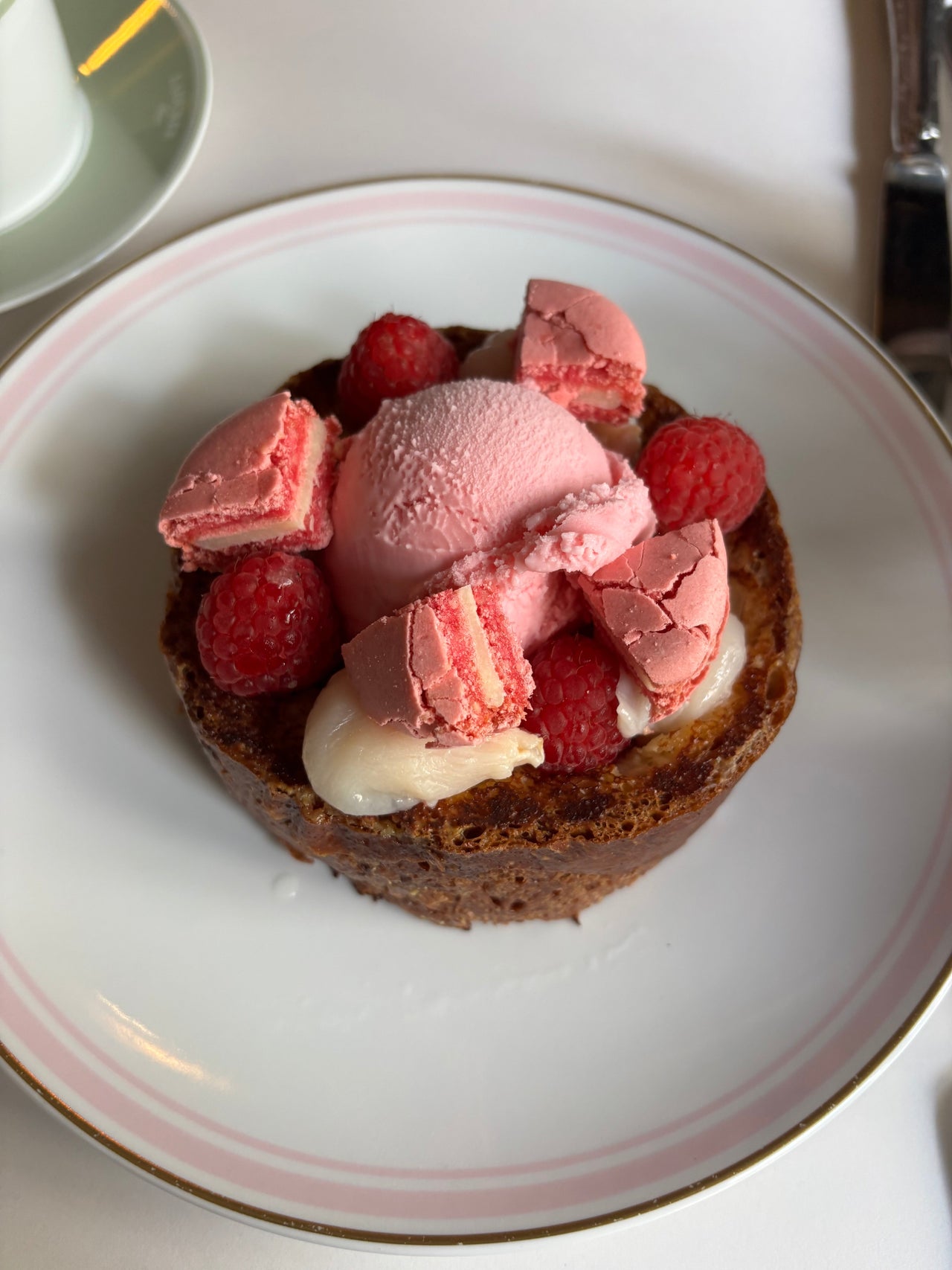 Ladurée Ispahan Pain Perdu in Paris featuring caramelized brioche French toast topped with rose cream, raspberries, lychee, and a signature macaron.